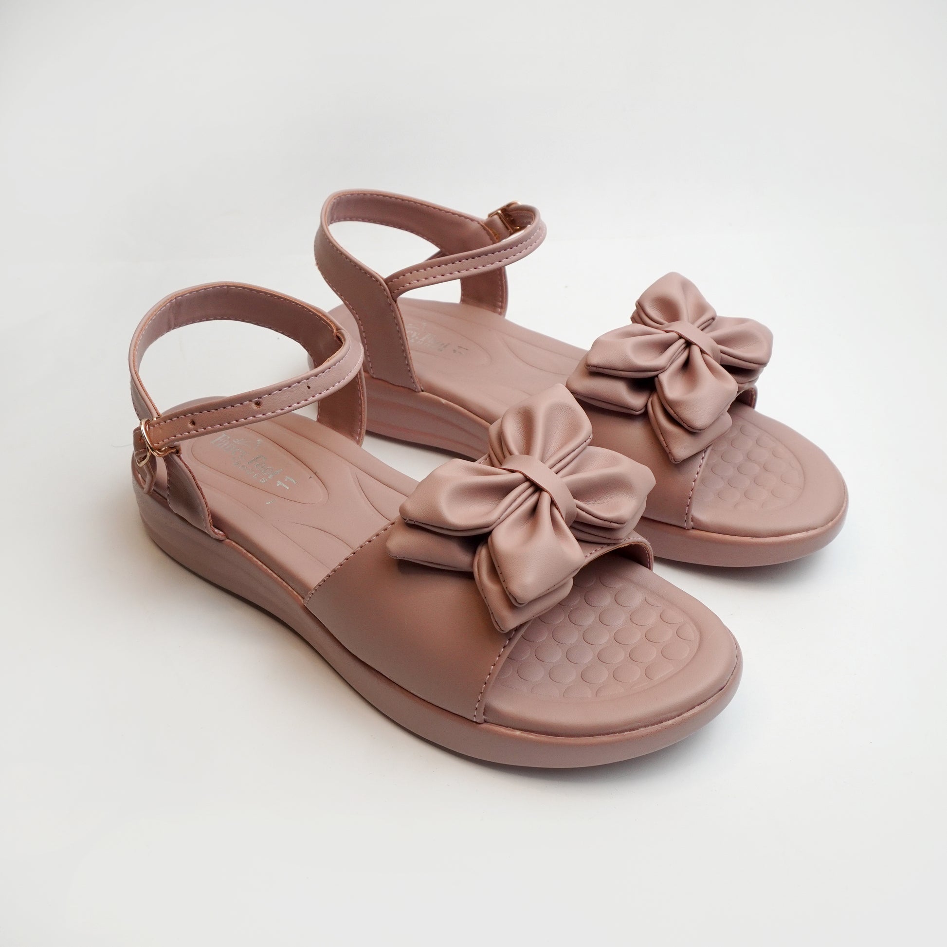 Women’s tan flat sandals with bow detail – comfortable and trendy casual summer footwear.